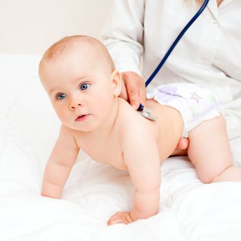 Children's doctor exams infant with stethoscope