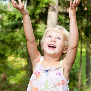 Portrait of cute little girl with hands up in happiness