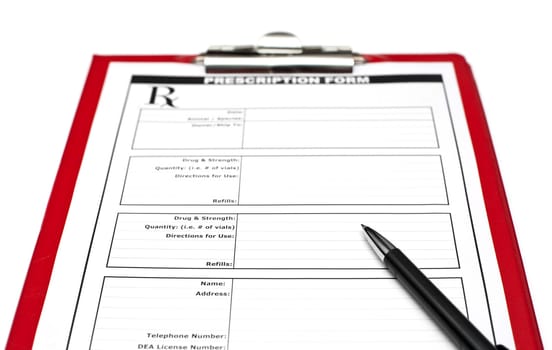 Blank prescription form on red clipboard with pen, focus on pen