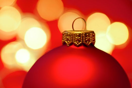 Red Christmas bauble with blured lights in background, very shallow DOF