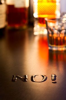 The word No! written with spoiled whiskey on a table, shallow DOF