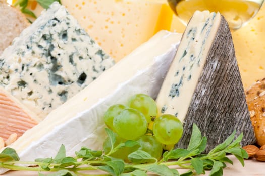 Various types of cheese with grapes close-up