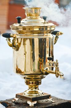 Vintage smoking golden Samovar, the traditional russian water boiler