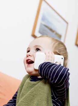 young child on couch with white cell phone