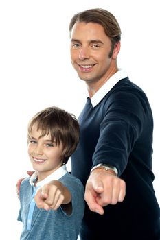 Charming father and son pointing at you posing sideways. White background.