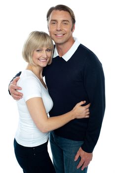 Stylish man in pullover embracing his blonde wife. Both smiling at the camera.
