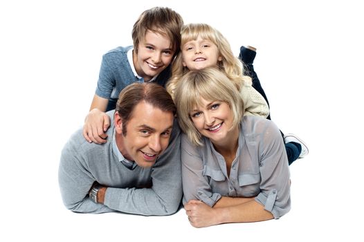 Adorable young kids piled on top of their parents. Studio shot