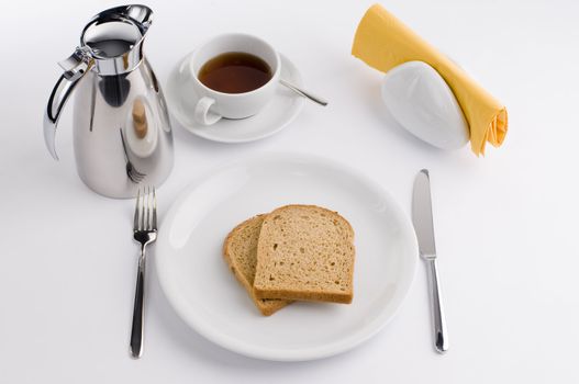 Breakfast table with thermos cup and white china, olive, tomato and bread