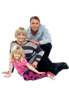 Young family of three posing indoors. Studio shot over white background.