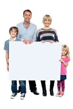 Active young family displaying a blank ad board to the camera. Full length portrait