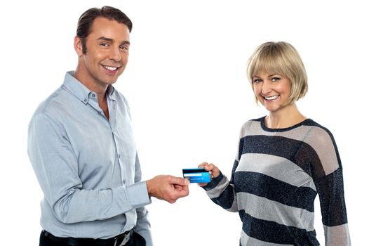 Middle aged couple showing a cash card to the camera. Half length portrait.