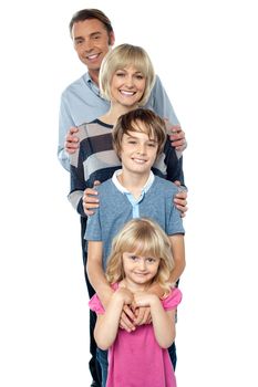 Sweet little family of four posing one behind the other. Indoor studio shot.