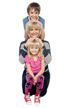 Mother posing with her adorable son and daughter. Studio shot over white.