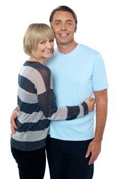 Charming middle aged lady embracing her husband isolated over white.