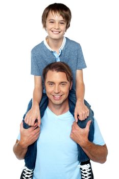 Cheerful son enjoying a piggyback ride on his father's shoulder. Studio shot.