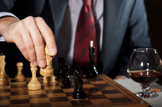 image of the businessman in a business suit plays chess