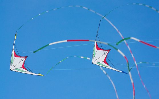 Two kites flying in the blue sky