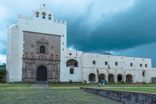 Monastery of San Augustin, declared a national monument in 1933, the monastery of San Agustín was built between 1539 and 1580 with most of the work being done after 1550. The walls are of rubble-stone construction and covered in plaster, topped by battlements, and the overall appearance is that of fortress. The crown of battlements, the single bell tower, the open chapel and the Plateresque facade identify the complex as a classic 16th century religious construction. The fortress appearance of complexes of this time were not literally for protection but rather served to dominate the landscape much as mediaeval castles in Europe did. In areas where there are carefully fitted stones, these stones have been carved. The construction of the monastery is attributed to Andrés de Olmos. Restoration work has been done in this complex since the 1920s, which has revealed all of the church’s facade and the atrium is terraced down to its original level of construction. This has exposed the flood damage from the colonial period. Most of the murals and frescos had been buried under years of plaster and paints before being restored