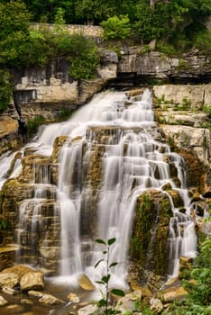 Inglis Falls in Owen Sound Ontario Canada. The Sydenham Rivers pours over rock formation of limestone shelves creating an 18 meter high cascade that has carved a deep gorge at the base of falls.