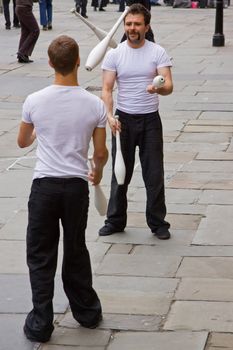BATH, ENGLAND - MAY 14: Jugglers practice their art before performing for large groups of spectators outside the Pump Rooms in Bath, England on May 14, 2010