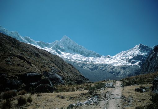 Valley in Peru with towering Andes Mountain peaks rising in background