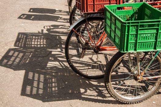 Bicycles with green and red baskets in bright sunlight
