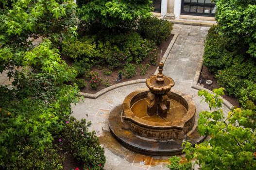 Beautiful fountain in green leafy courtyard