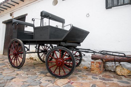 Old black wagon in small colonial town in Colombia