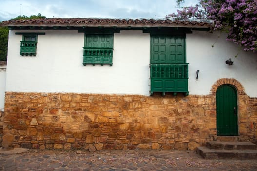 White colonial house with windows of three different sizes