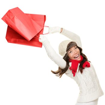 Winter and christmas shopping. Woman holding red shopping bags happy, ecstatic and cheering with energy, Isolated on white background.