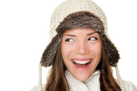 Winter woman looking sideways happy isolated on white background. Closeup portrait of beautiful winter girl wearing warm clothes and winter hat looking to the side. Chinese Asian / Caucasian female model.