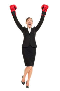 Success business woman standing cheering with arms in air wearing boxing gloves - business concept with businesswoman in full body celebrating happy. Young Asian / Caucasian female professional isolated on white background.