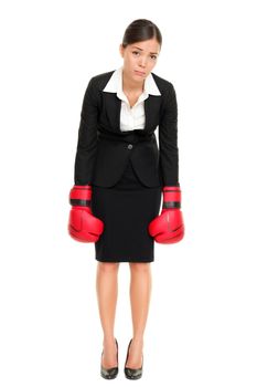 Defeated loser woman - business concept with businesswoman wearing boxing gloves standing in full body looking hopeless. Young Asian / Caucasian female professional isolated on white background.