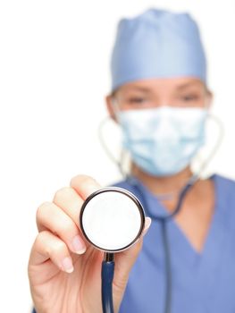 Medical doctor showing stethoscope close up isolated on white background. Female nurse or doctor wearing surgical mask and hat. Woman model.