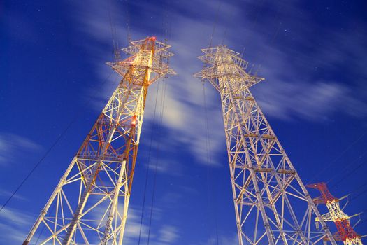 huge metallic pylons against night windy sky