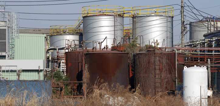 rusty pipes and huge barrels of old heavy industrial factory facilities