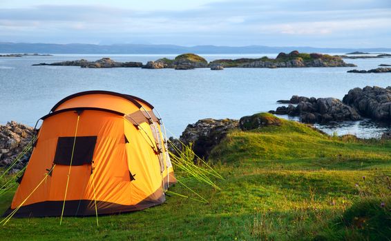 Camping tent on an ocean shore in a morning light