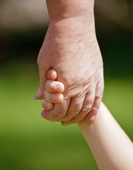 Grandmother holding granddaughter's hand closeup