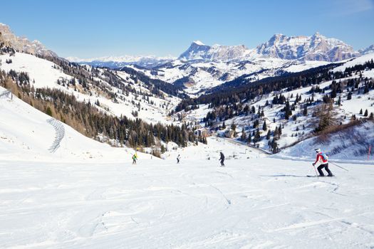 Skiers going down the slope at Sella Ronda ski route in Italy