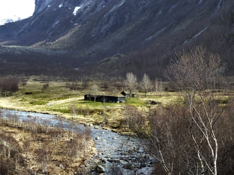 cottage in the mountains of norway with river and birch trees