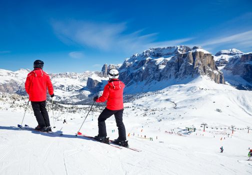 Skiers overlooking the piste at Val Di Fassa ski resort in Italy