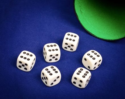 Six dice with number six facing up on blue board