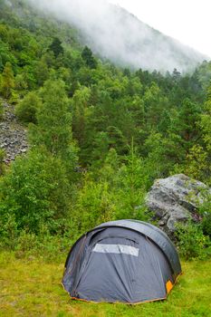 Camping tent beside a foggy mountain in Norway