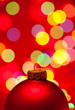 Red Christmas bauble with blured lights in background, very shallow DOF