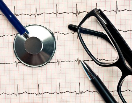 Stethoscope and glasses lying on ECG diagram