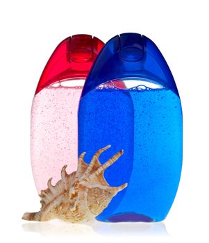 Blue and crimson transparent shampoo bottles with shell on white background