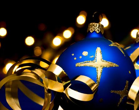 Blue Christmas bauble with blurred lights in background, shallow DOF