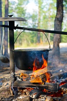 Camping kettle over burning campfire