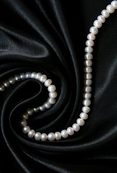 White pearls on the black silk can use as background