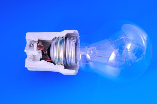 cut ceramic cartridge with a light bulb photographed against a blue background